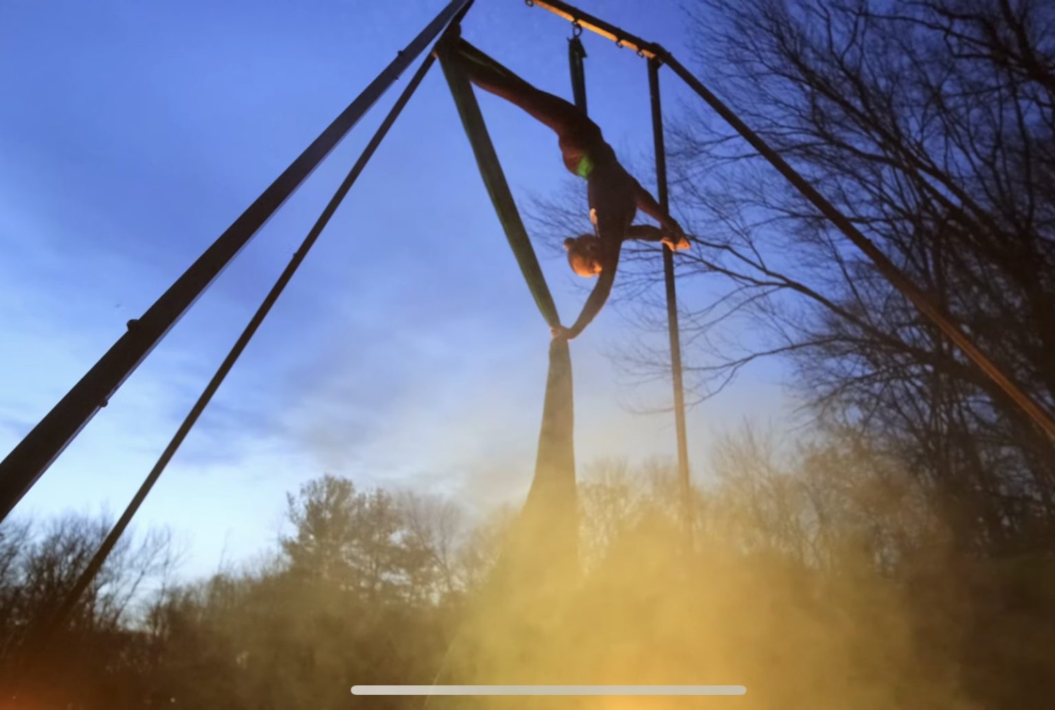 Aerialist performs she splits upside down on an aerial fabric